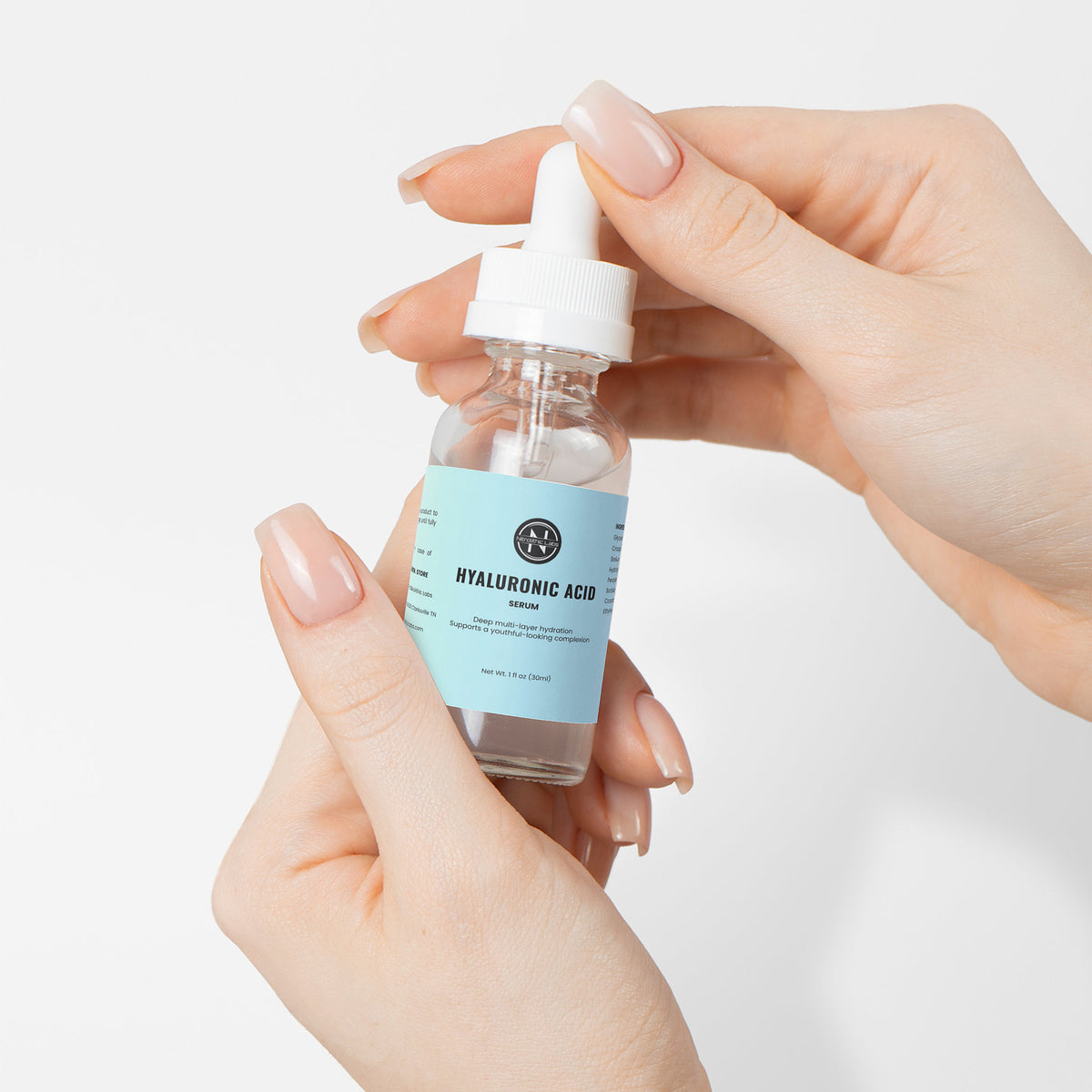 Hyaluronic Acid Serum dropper bottle held between hands